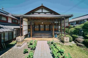 Front view of a traditional Buddhist temple in Nagahama, Japan, with wooden architecture and a small garden path