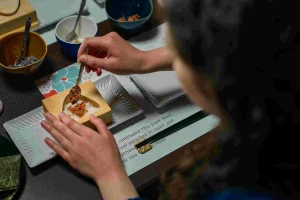 A guest making a Japanese onigiri rice ball during a hands-on breakfast experience in Nagahama