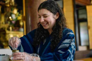 A participant enjoying a hands-on cultural activity during a temple experience program in Nagahama